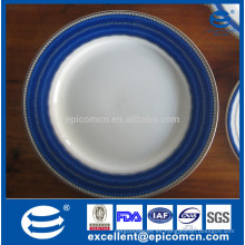 Platos blancos de la vajilla con los bordes azules rim los platos de servicio azules